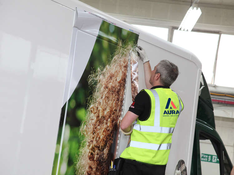 Aura Brand Solutions Fitter installs vehicle wrap